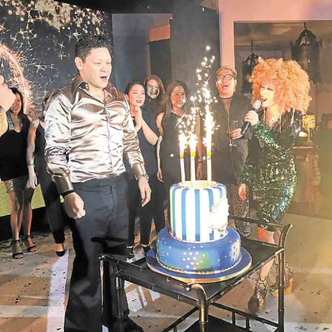 Birthday boy Anton San Diego blowing his cake