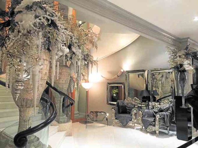 Wintry decor of silver, black twigs, snowy white icicles arranged in giant carved oriental vases are a counterpoint to a vignette of metallic gray and animal skin print.