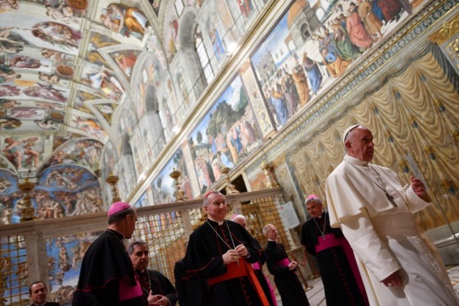 Pope Francis flanked by the prefect of the papal household Georg Gaenswein (L) and Vatican Secretary of State Pietro Parolin (C) walks in the Sistine Chapel during an audience with the Members of the Diplomatic Corps accredited to the Holy See for the traditional exchange of New Year greetings on January 9, 2017 in Vatican.  / AFP PHOTO / POOL / Alberto PIZZOLI