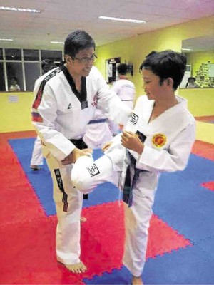 John Paul Ampongan teaching a student on proper kicking technique