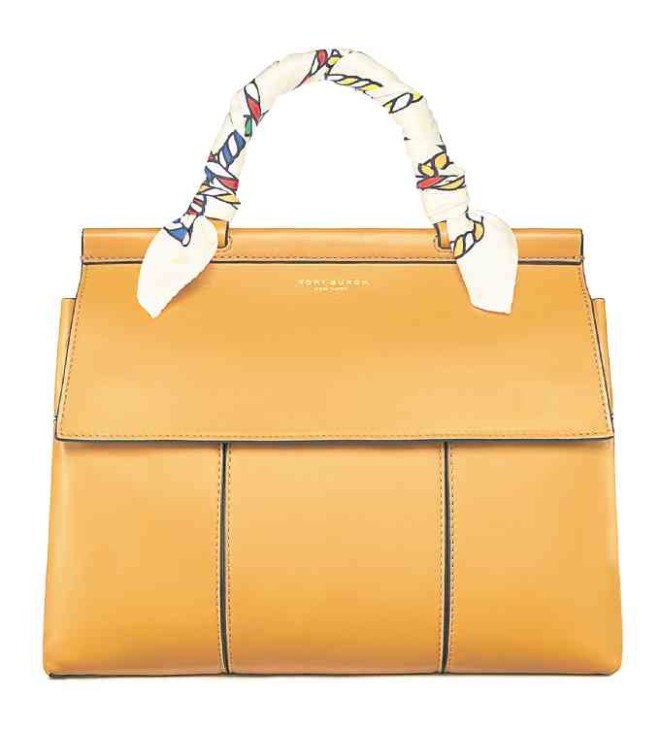 Key bag from the commercial collection: Block T leather satchel with crossbody strap, top handle tied with Tory Burch silk scarf. The bag comes in several colors.