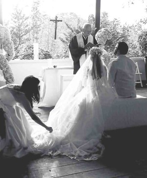 Matron of honor adjusting the bride’s veil