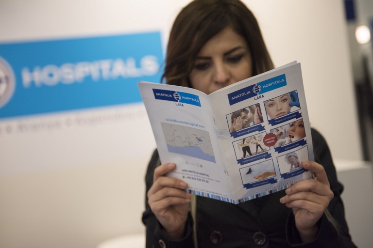 This file photo taken on March 08, 2017 shows a hostess posing with information material for a hospital in Turkey at a section for medical tourism at the International Tourism Trade Fair (ITB) on March 8, 2017 in Berlin. / AFP PHOTO / STEFFI LOOS