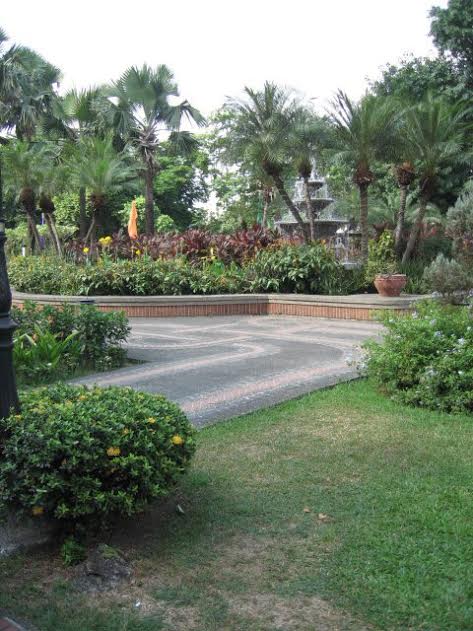 Garden landscaping uses adobe and brick for walkways while framing views of Fort Santiago and Manila Cathedral in lush tropical foliage. —CARLOS CELDRAN