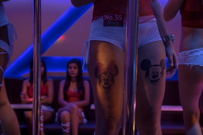 This photo taken on March 29, 2017 shows young women waiting for customers at a go go dance bar in Walking Street in Pattaya. Two hours east of Bangkok, Pattaya's bawdy reputation hails from the Vietnam War era when US GIs partied in their downtime. / AFP PHOTO / Roberto SCHMIDT / TO GO WITH Thailand tourism crime social,FEATURE by Jerome TAYLOR
