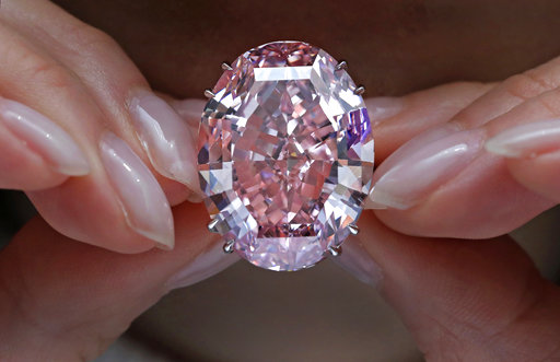 In this Wednesday, March 29, 2017, file photo, the "Pink Star" diamond, the most valuable cut diamond ever offered at auction, is displayed by a model at a Sotheby's auction room in Hong Kong. The stunning 59.6 carat diamond has sold for HK$553 million or US$71.2 million at a Sotheby's auction in Hong Kong, setting a record for any diamond or jewel. It's Also the highest price for any work ever sold at auction in Asia. AP FILE PHOTO