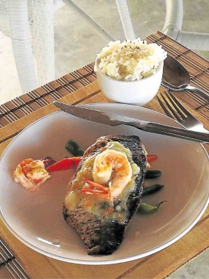 Pan-seared sea bass with shrimp and lemon caper sauce, served with garlic fried rice 