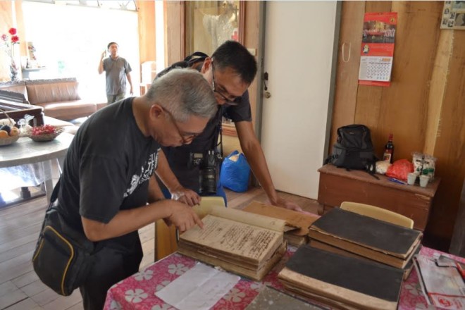 Regalado Trota Jose and Romeo Galang Jr. inspecting old canonical books