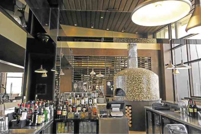 The stone, wood-fired pizza oven imported from Italy is the focal point of themain bar.