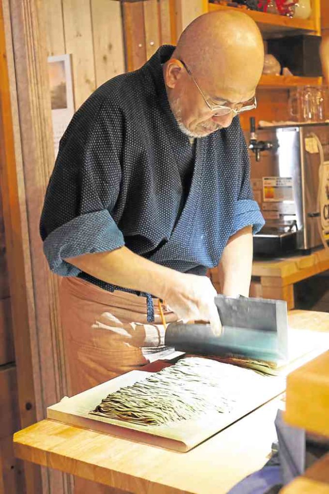Soba master Rai using the soba “kiri” to cut the dough