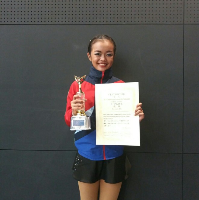 Iriga cheerleader Junia Febe Marie Callos holds the first place certificate and trophy.