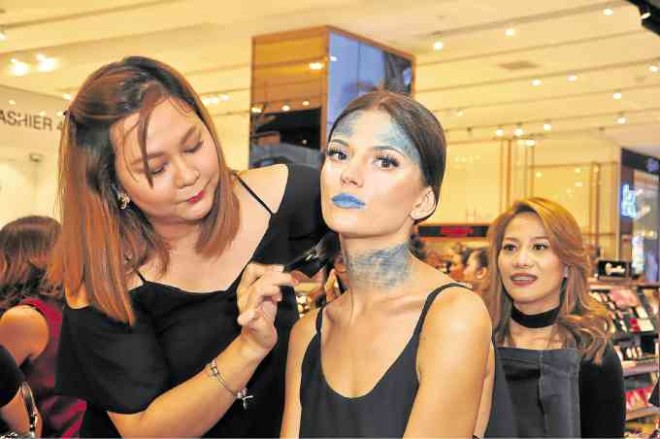 Muriel Jada Nubla applying makeup on the neck of model Alla Alla