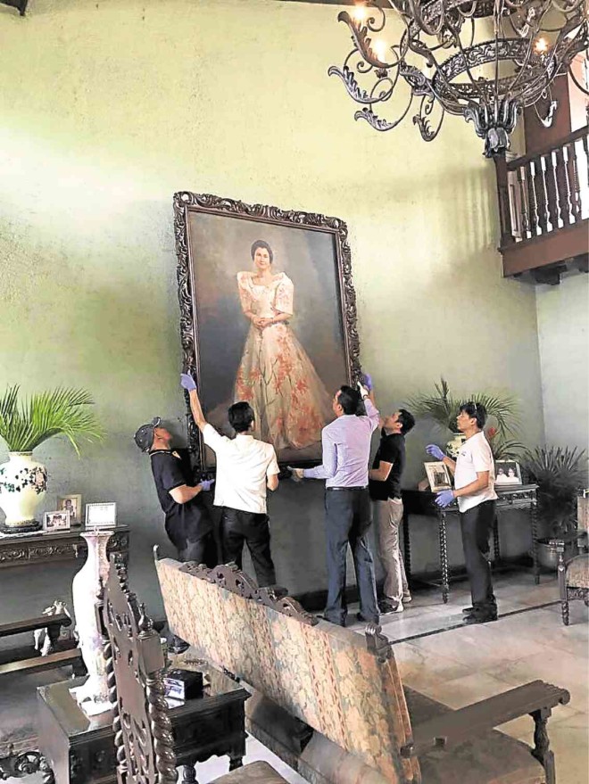 National Museum director Jeremy Barnes (in long-sleeved shirt) leads the Museum staff in taking down the huge Amorsolo portrait of Susana Bernardo Ramos, to be brought to the National Museum.