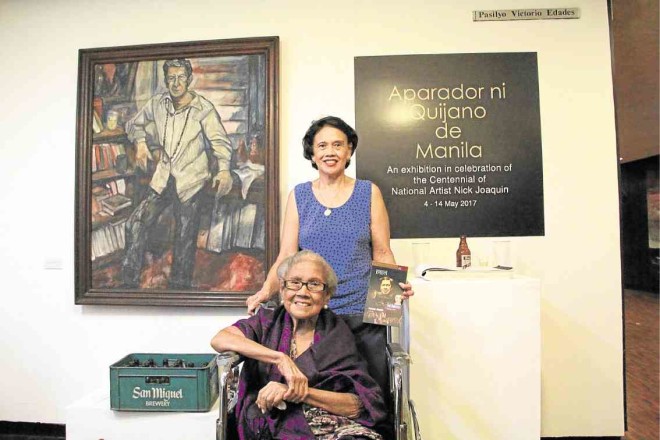 Elena Roco (on wheelchair) and daughter Marissa before Danny Dalena’s portrait of Nick Joaquin and beside a case of San Miguel beer. Roco, a retired mathematics and Spanish professor at UST, wasNJ’s “Muse” and beer buddy. —PHOTOS BY VINZ LAMORENA