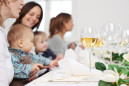 women with children sitting at table in restaurant