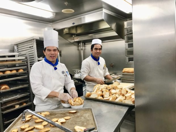 Filipino bakery chefs all smilesin the main galley of the Voyager of the Seas royal caribbean