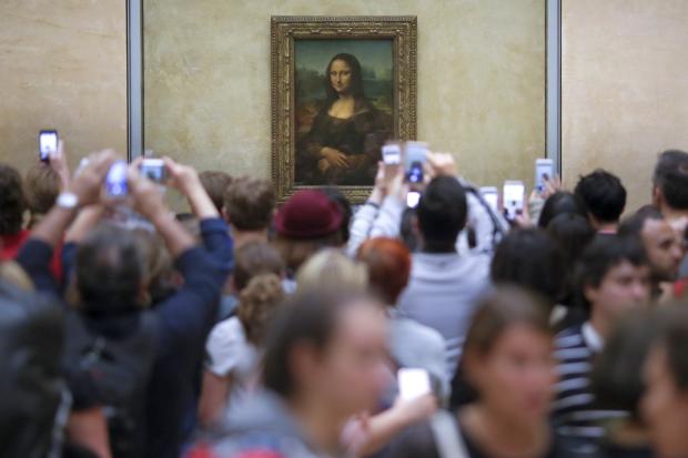 Louvre visitors in front of Mona Lisa