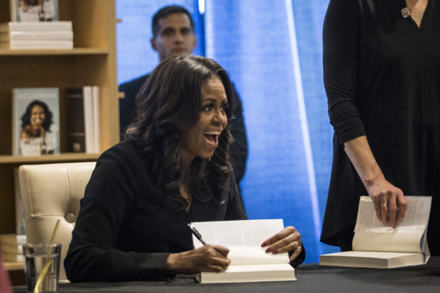 Former first lady Michelle Obama signs copies of her new book "Becoming" and greets fans as she kicks off a national book tour at Seminary Co-op Bookstore in Chicago, Tuesday, Nov. 13, 2018. (Ashlee Rezin/Chicago Sun-Times via AP)