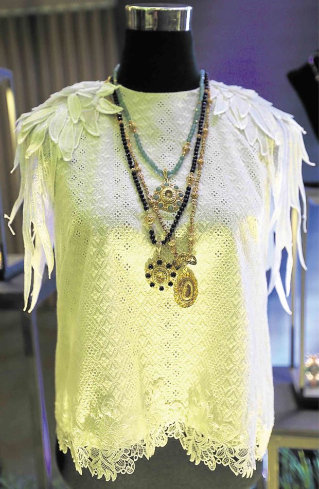 Layered pendant necklace by Elena Bautista on a white top by Rhett Eala