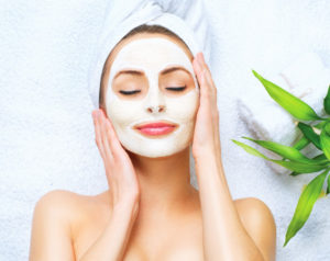spa woman applying facial cleansing mask