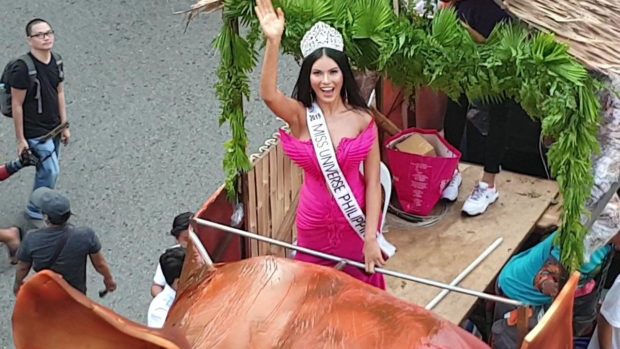 Beauty queen dazzles atop giant roast pig