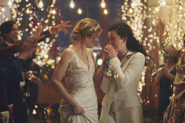 This image made from undated video provided by Zola shows a scene of its advertisement. Under pressure from a conservative advocacy group, The Hallmark Channel has pulled the ads for wedding-planning website Zola that featured same-sex couples, including two brides kissing. The family-friendly network, which is in the midst of its heavily watched holiday programming, removed the ads because the controversy was a distraction, a spokesperson said in an interview on Saturday, Dec. 14, 2019. (Zola via AP)