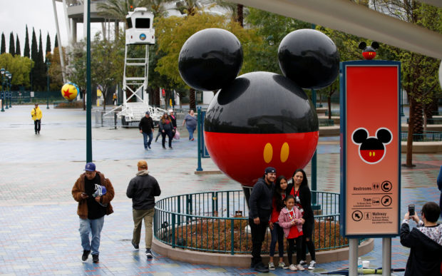 A family poses for a photo at Disneyland theme park in Anaheim, California, U.S., March 13, 2020.
