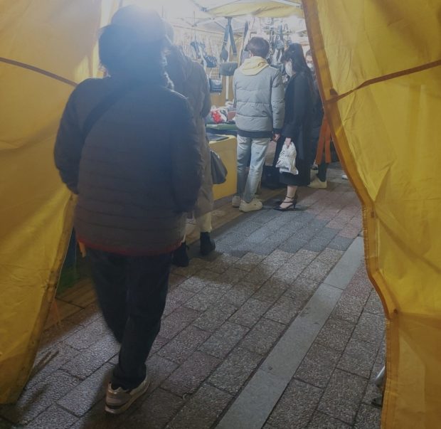 Shoppers at Dongdaemun Saebit Market look at counterfeit luxury items on Wednesday night