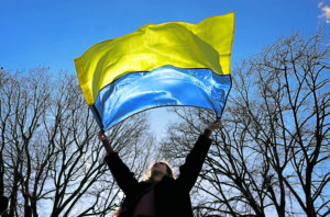 The Ukraine flag being held aloft by a woman during a demonstration in front of the White House. —REUTERS