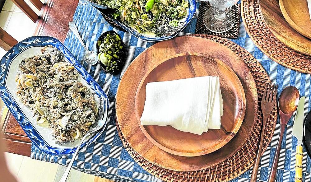 “Kulawo,” or chargrilled banana blossoms with smoked coconut cream, on a setting of wooden plates and cutlery, “nito” charger and “inabel Iloko” tablecloth