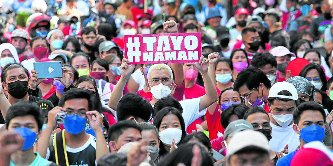 A protester holds up a placard during a Labor day rally in Sampaloc, Manila on sunday