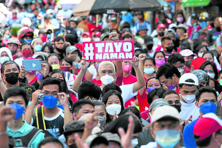 A protester holds up a placard during a Labor day rally in Sampaloc, Manila on sunday