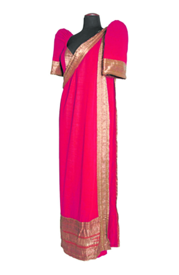 A red Indian-inspired piece, this terno has a one-shoulder sari-like detail and a bodice with embroidered gold trim.