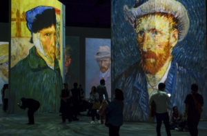People look at screens displaying paintings by Dutch artist Vincent Van Gogh during the official opening of the "Beyond Van Gogh : The Inmersive Experience", in Bogota, on July 10, 2022.