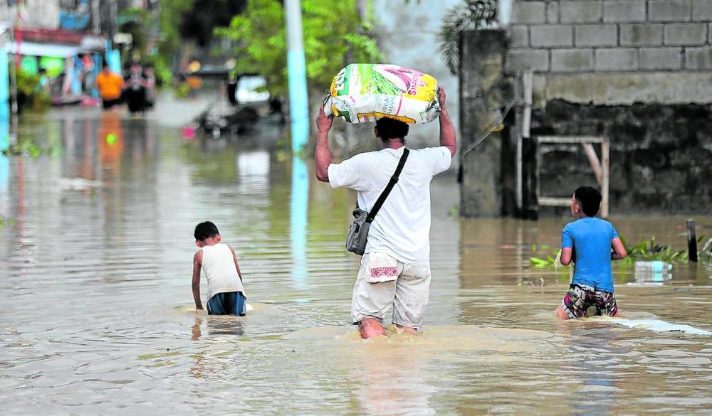 Residents wade in flood waters in San Miguel, Bulacan, a day after the onslaught of Supertyphoon “Karding” (international name: Noru). Wading in floodwaters exposes one to diseases