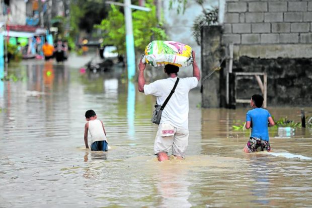 Residents wade in flood waters in San Miguel, Bulacan, a day after the onslaught of Supertyphoon “Karding” (international name: Noru). Wading in floodwaters exposes one to diseases.