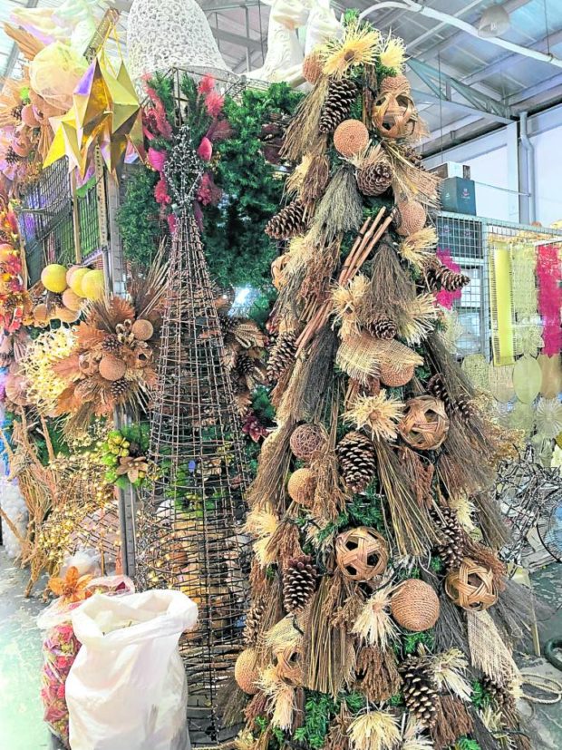Earth-toned Christmas tree decked with sinamay, fringed raffia, rattan balls and large pine cones
