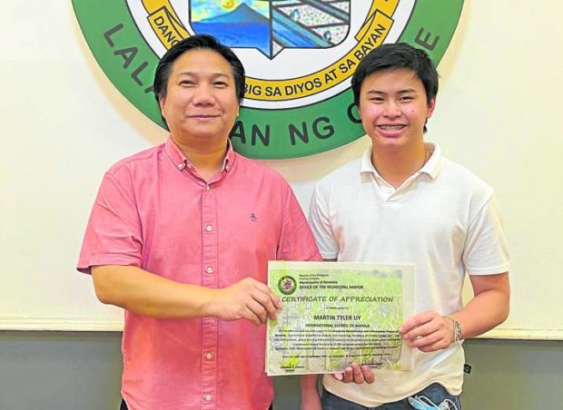 Uy receives a certificate of appreciation from Noveleta Mayor Dino Reyes-Chua for planting 10,000 mangrove trees.