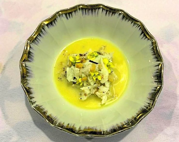 Crab with puffed rice and pili on a clam and caramelized “bangus” broth