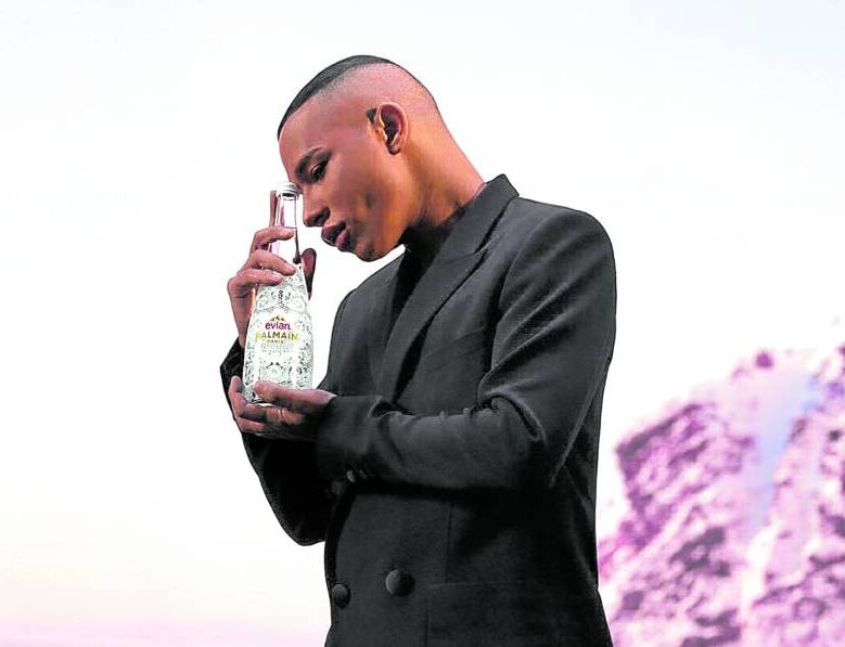 Olivier Rousteing withthe limited-edition Evian x Balmain glass bottle
