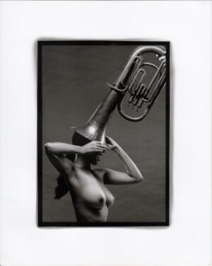 Nude photograph of a woman with a tuba over her head