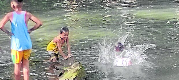 Children enjoy the shallow water of Disalet Creek. —Amadís Ma. Guerrero