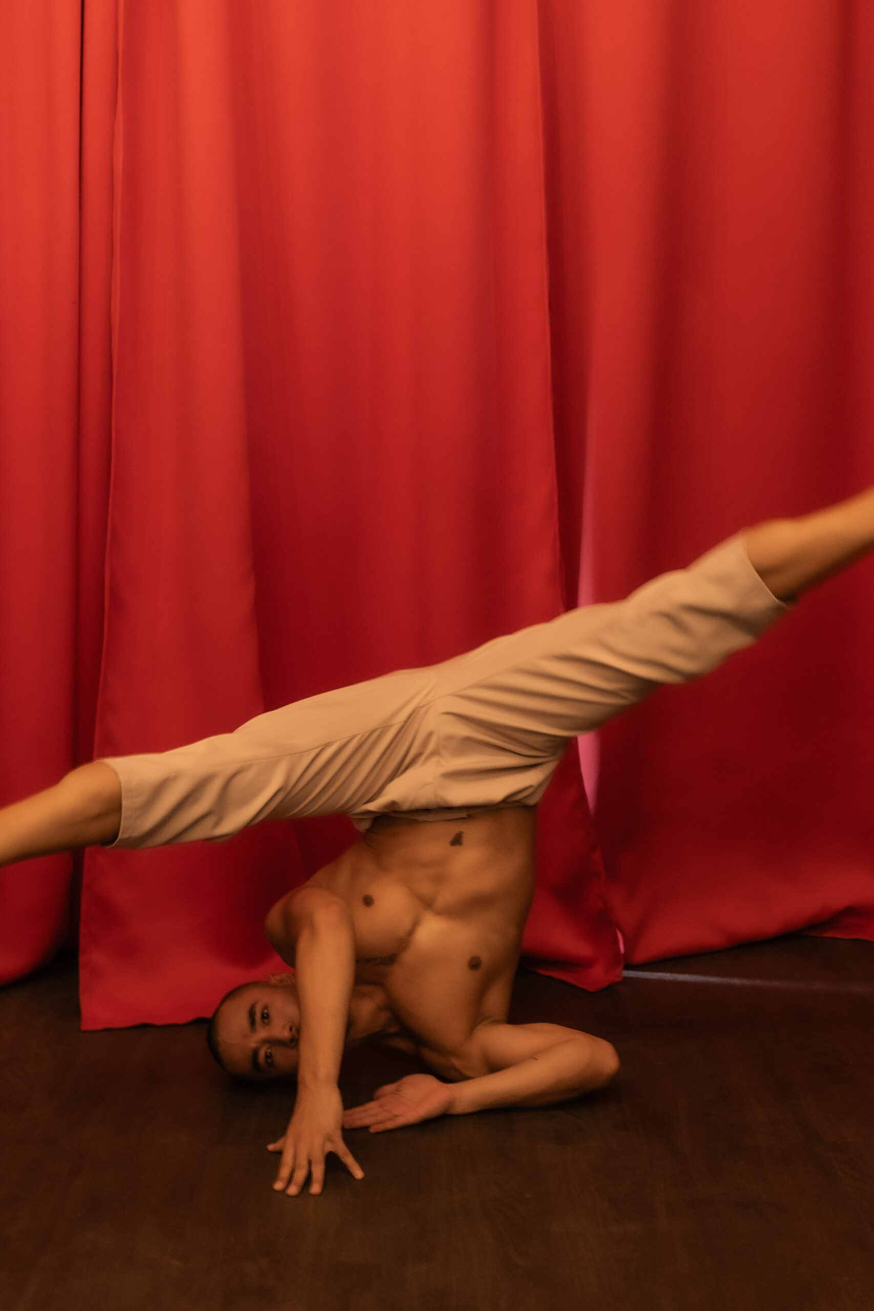 man headstand with red background