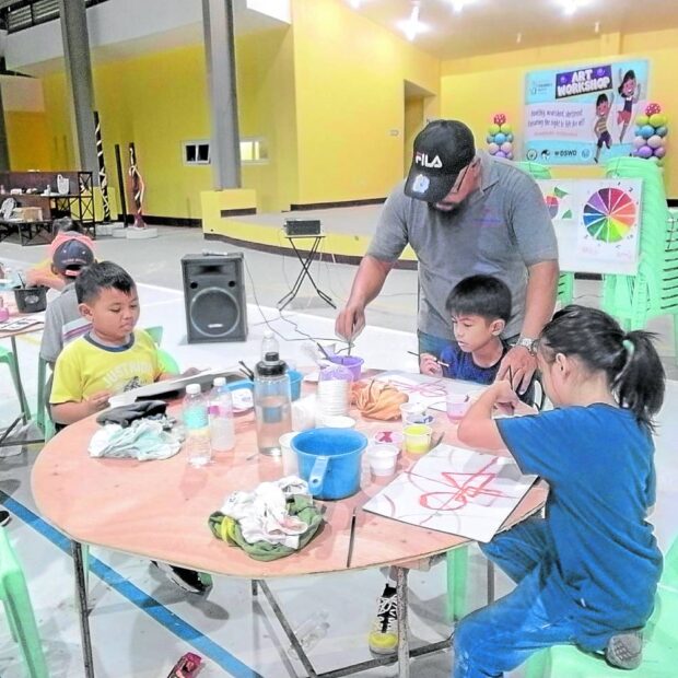 Workshop leader helps grade schoolers in the mixing of colors. (Amadís Ma. Guerrero)