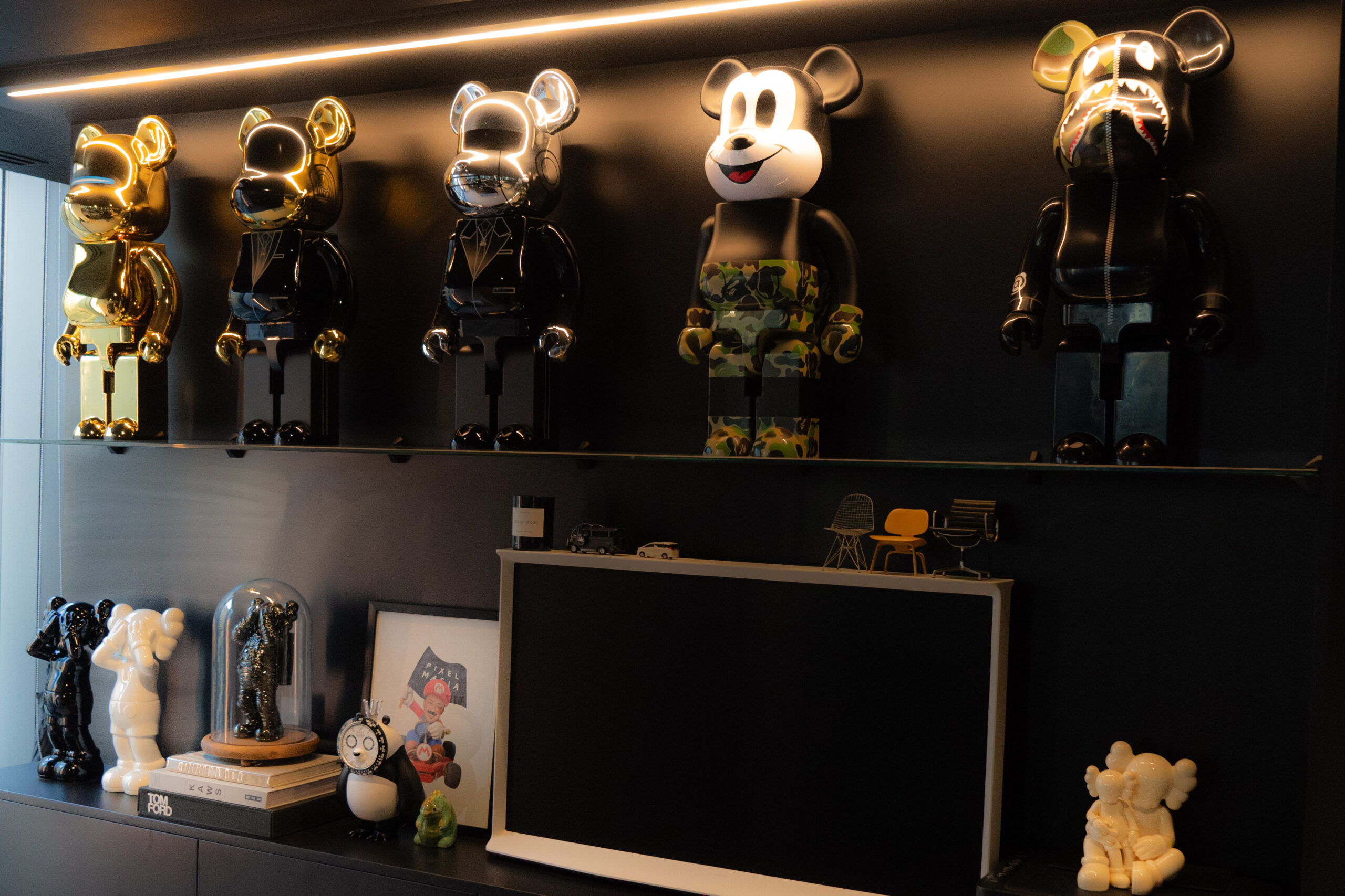 KAWS pieces take up the shelf space in Coby Chan’s office