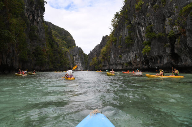 This photo taken on December 12, 2023 shows tourists paddling their kayaks inside the Big Lagoon in El Nido town, Palawan province. (Photo by Ted ALJIBE / AFP)