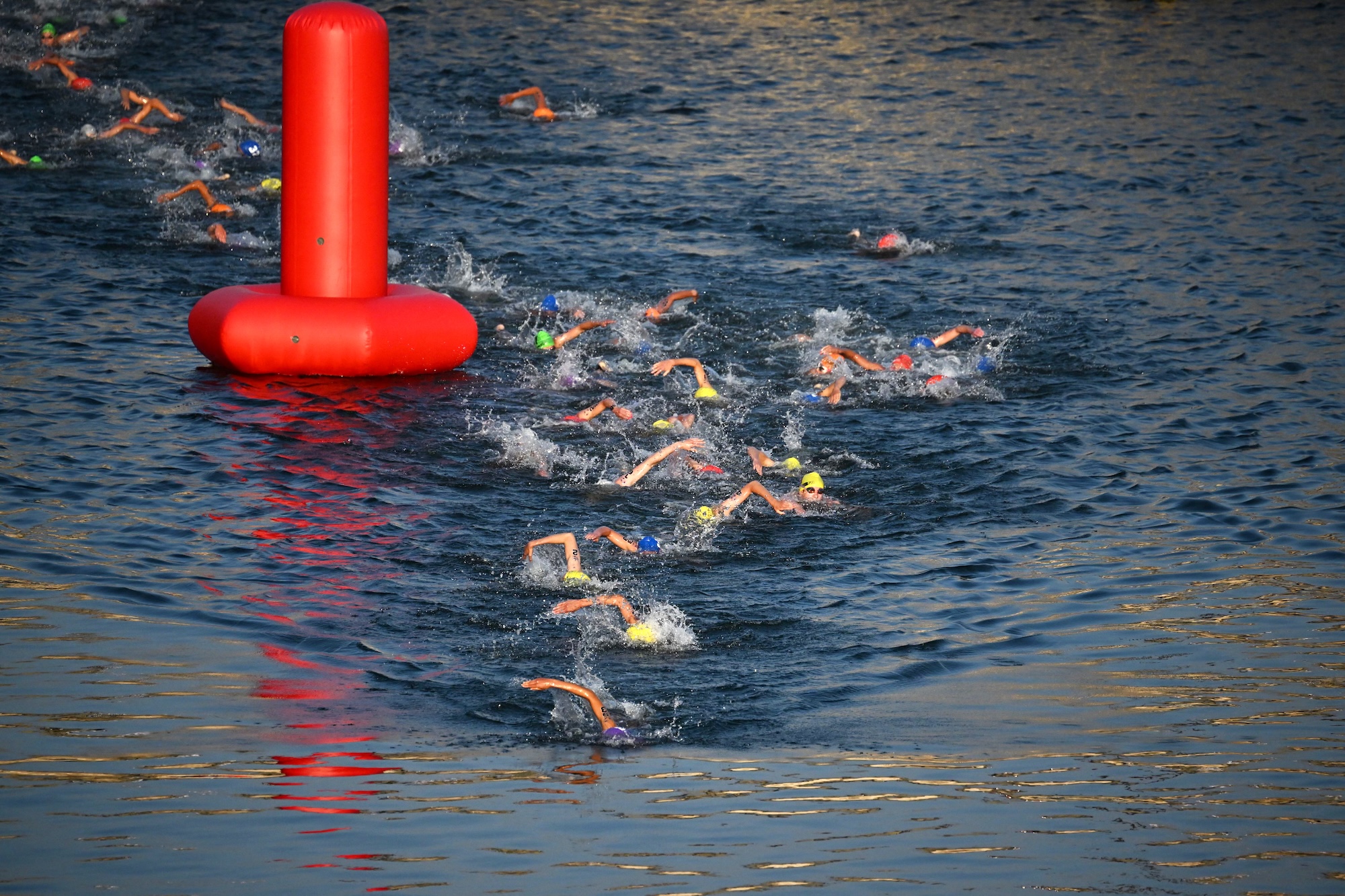 Triathlon athletes compete and swim in the Seine river during a Test Event for the women's triathlon for the upcoming 2024 Olympic Games in Paris, on August 17, 2023. From August 17 to 20, 2023, Paris 2024 is organising four triathlon events to test several arrangements, such as the sports operations, one year before the Paris 2024 Olympic and Paralympic Games. The swim familiarisation event follows the cancellation on August 6 of the pre-Olympics test swimming competition due to excessive pollution which forced organisers to cancel the pre-Olympics event. (Photo by Emmanuel DUNAND / AFP)