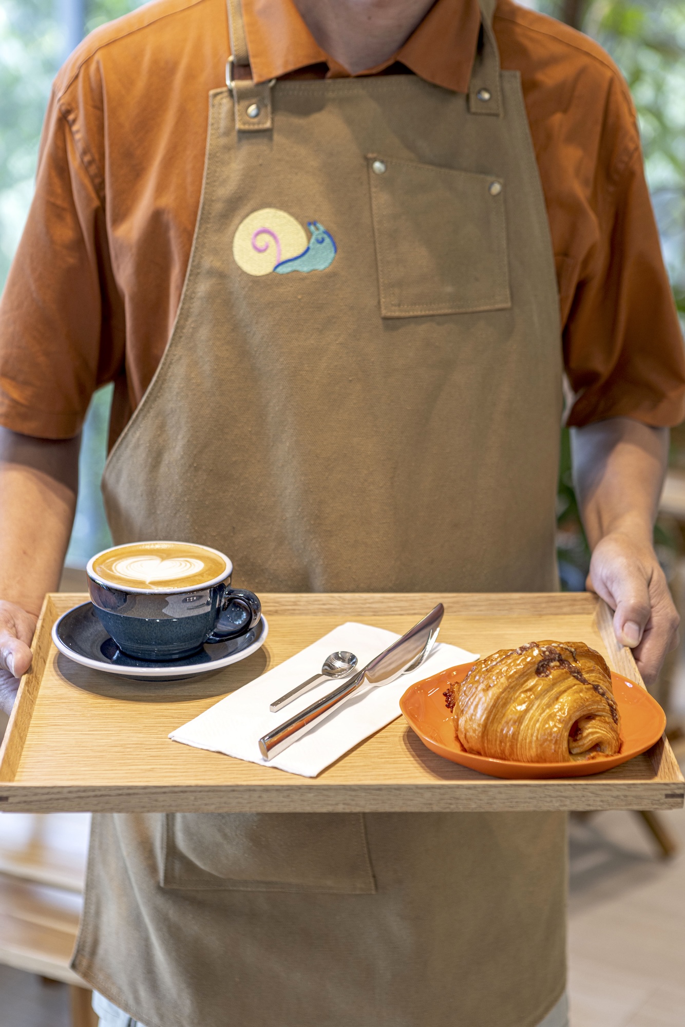 Croissants from Rebel Bakehouse while servers wear aprons with an embroidered snail