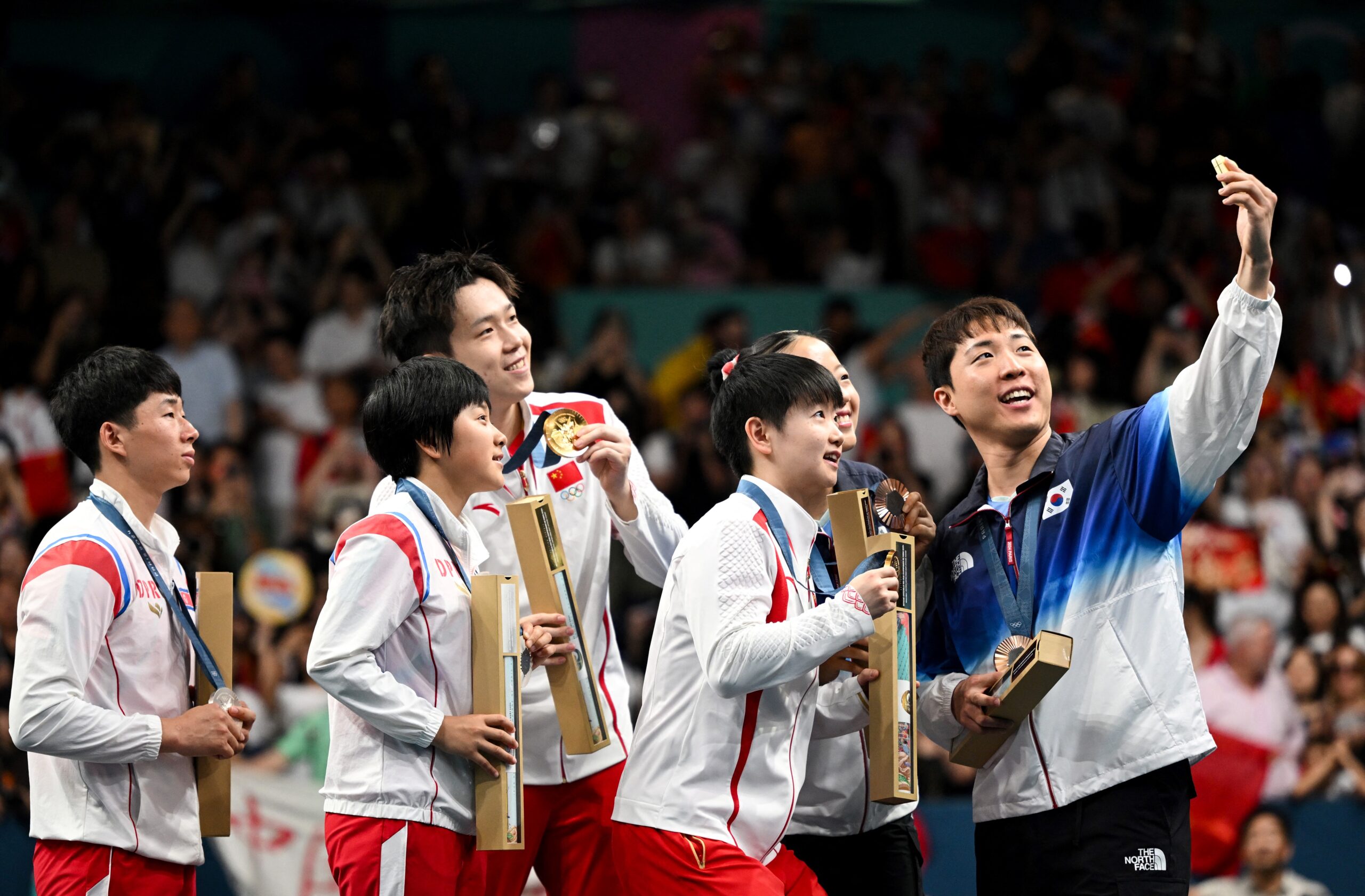 South korean medalists take selfie with north korean and chinese winners