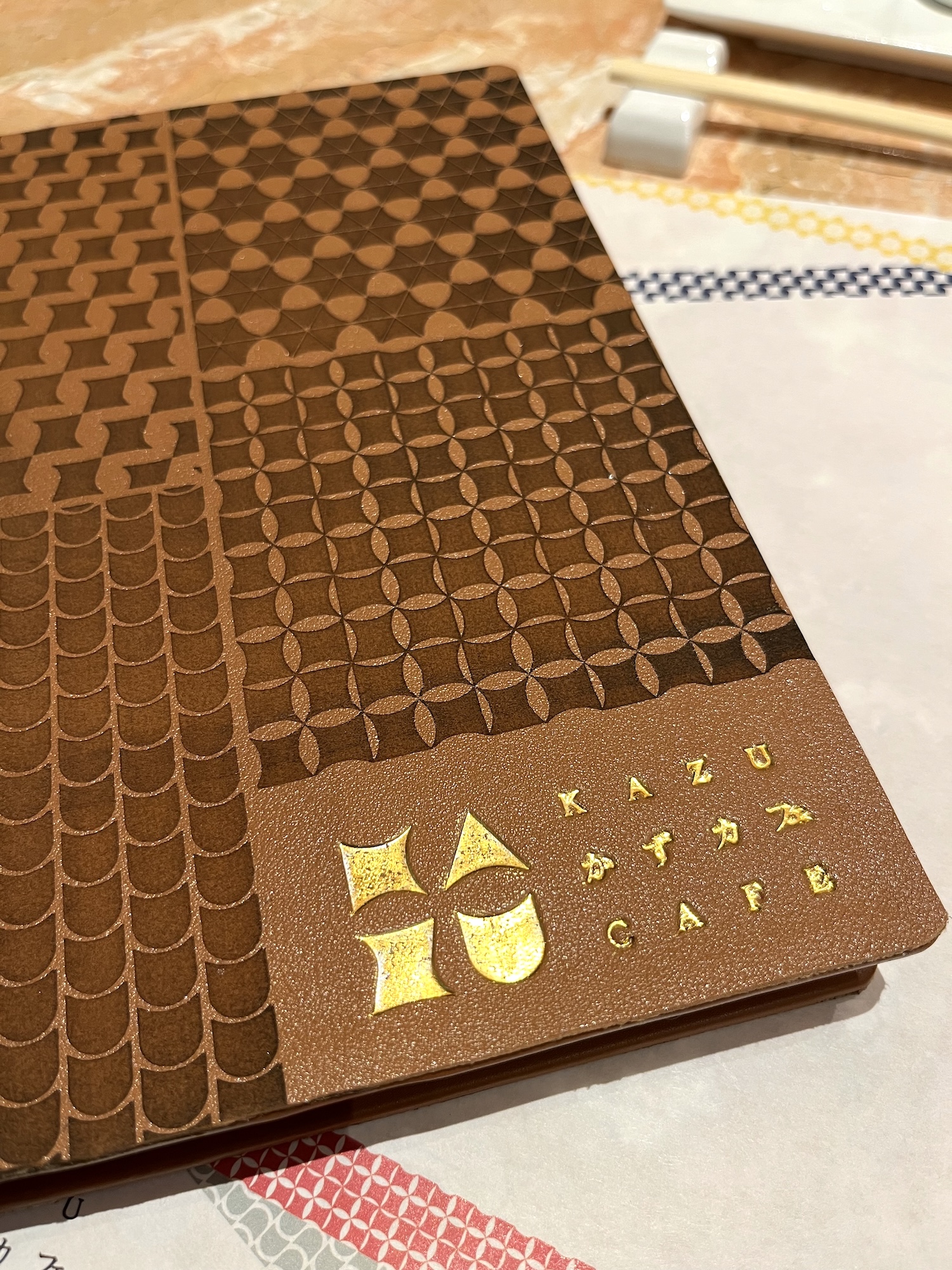 Embossed Kazu Café branding on the tactile menu